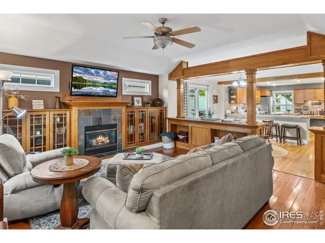 a kitchen with stainless steel appliances granite countertop a stove top oven a sink a dining table and chairs with wooden floor