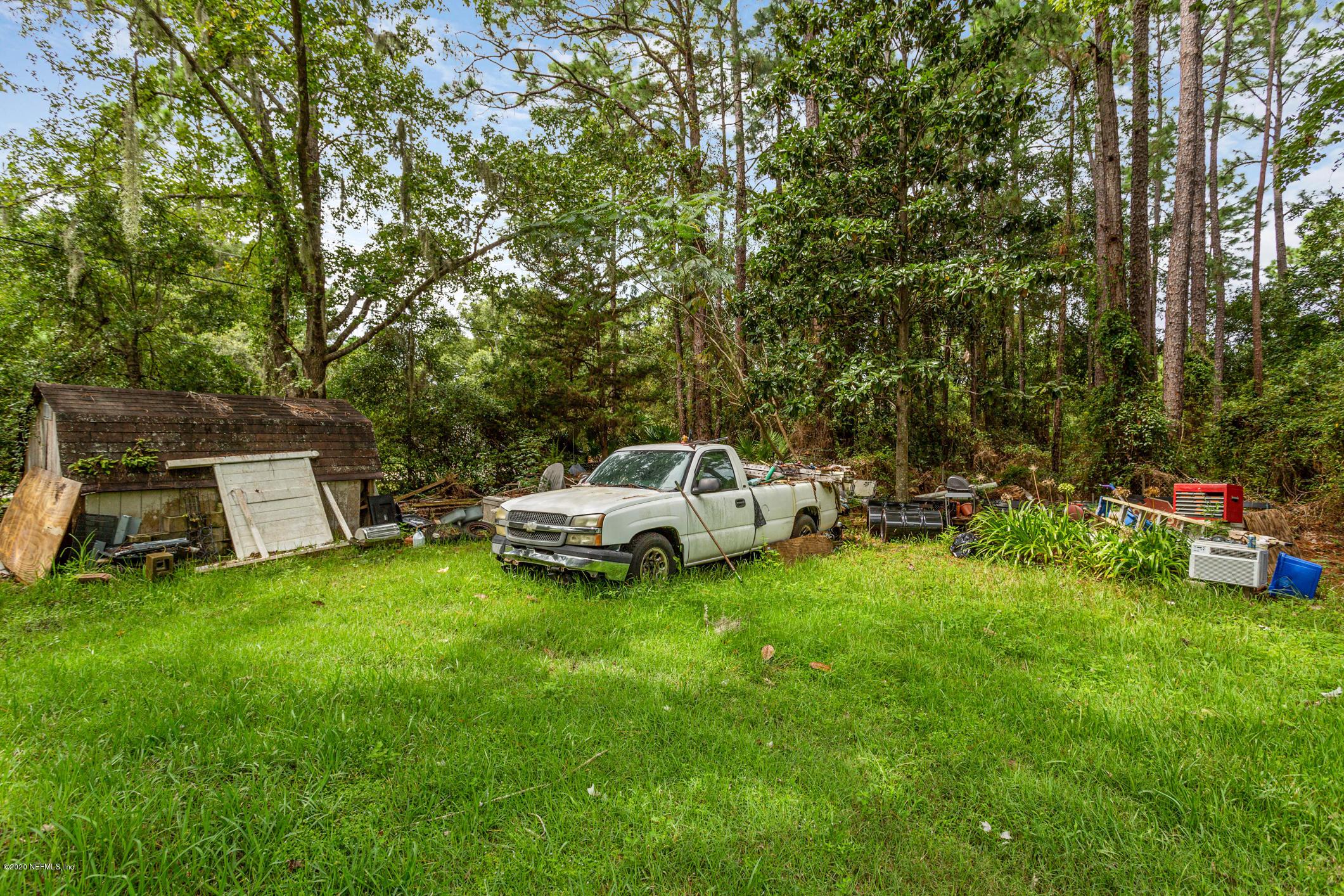 2837 Cortez Road Jacksonville, FL 32246 - Photo 5 of 16 a white house sitting in middle of the grass and trees