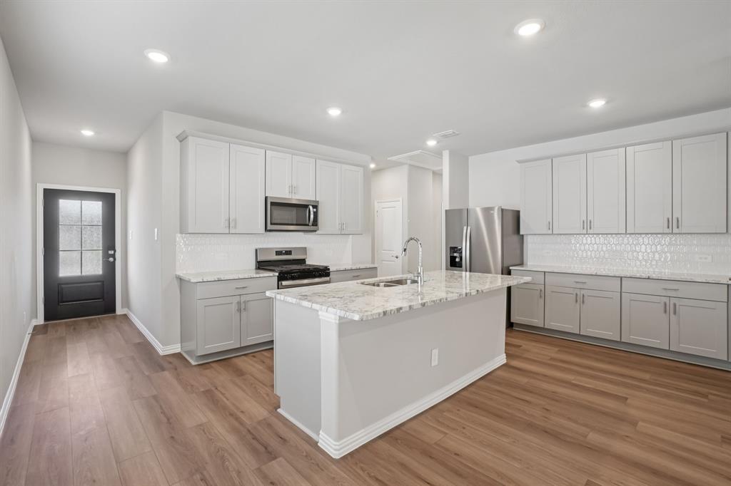 a kitchen with white cabinets and stainless steel appliances