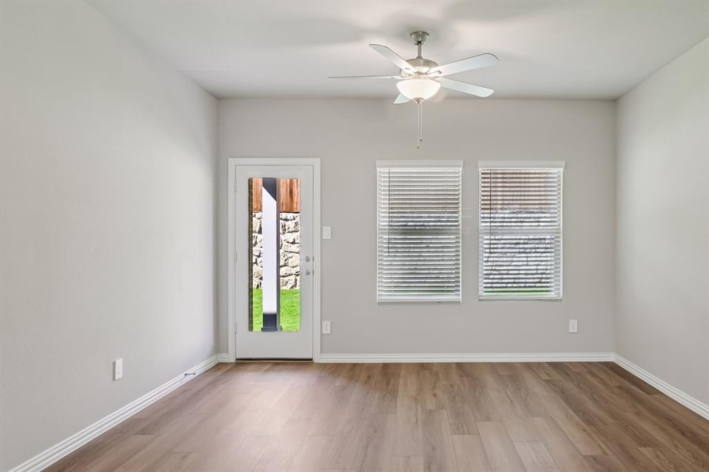 1725 Arches Road Anna, TX 75409 - Photo 15 of 28 an empty room with wooden floor chandelier fan and windows