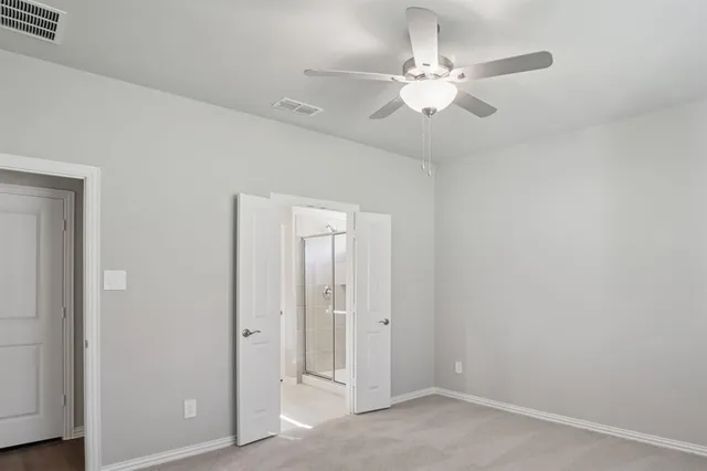an empty room with fan and entryway