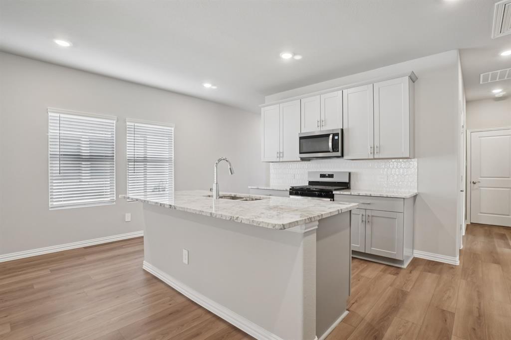 1725 Arches Road Anna, TX 75409 - Photo 4 of 28 a kitchen with appliances a sink and cabinets