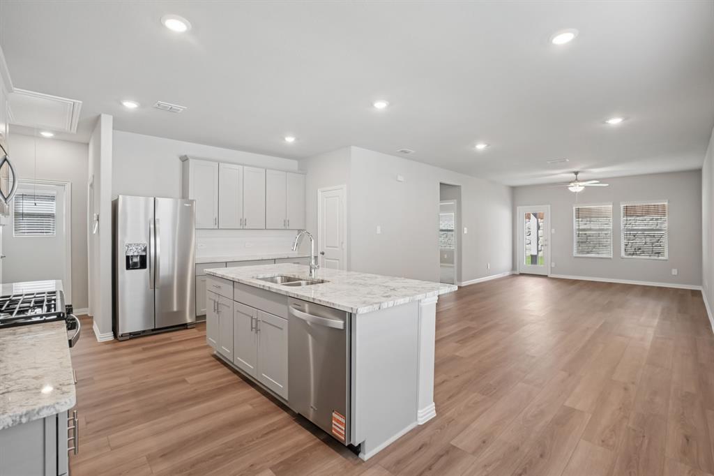1725 Arches Road Anna, TX 75409 - Photo 6 of 28 a kitchen with stainless steel appliances granite countertop a large counter top a sink and a refrigerator