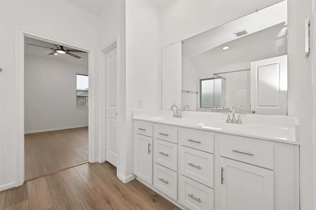 a bathroom with double vanity sink and a mirror