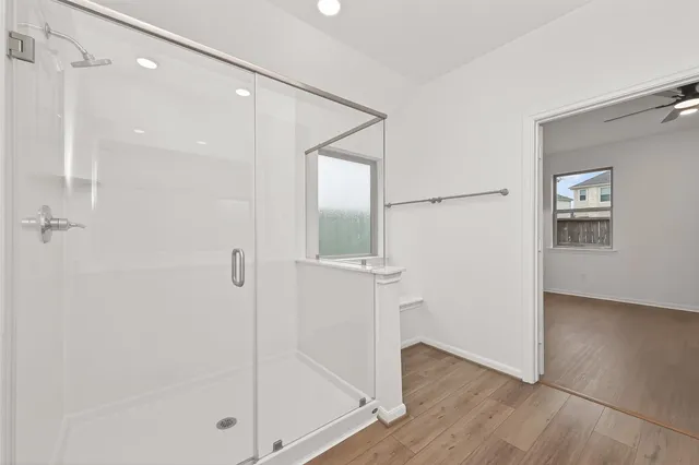 a bathroom with a glass shower door and a bathtub