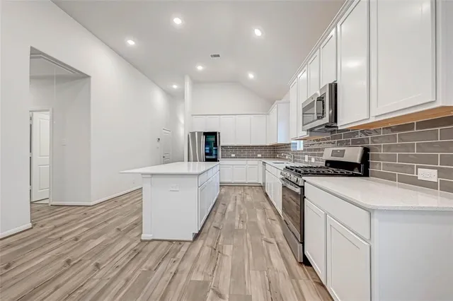 a kitchen with a sink a counter top space stainless steel appliances and cabinets
