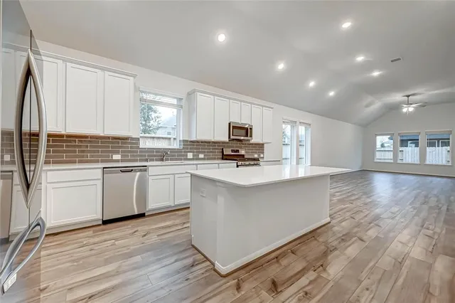 a kitchen with granite countertop white cabinets and white appliances