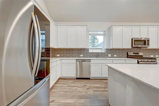 a kitchen with stainless steel appliances a refrigerator sink and microwave