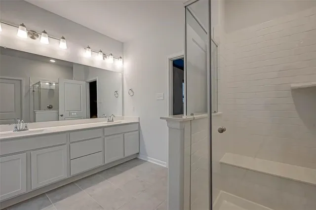a spacious bathroom with a double vanity sink a mirror and a bathtub