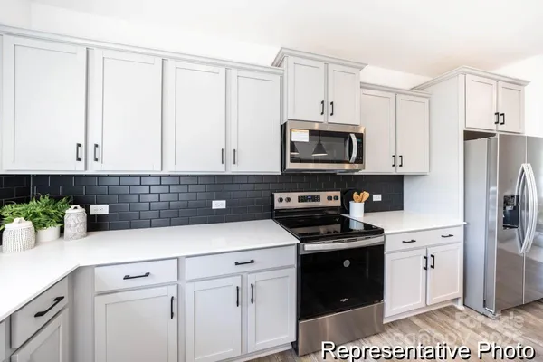 a kitchen with granite countertop white cabinets and stainless steel appliances