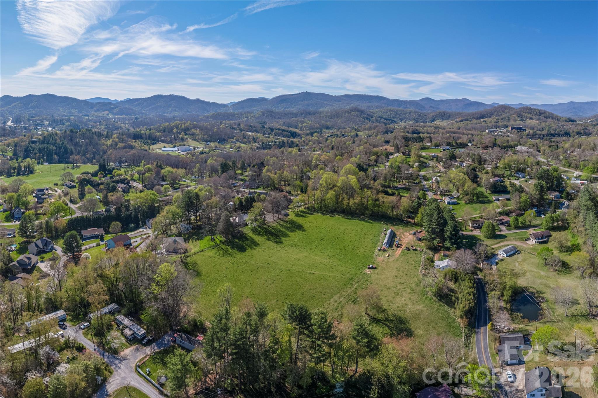 284 Woodland Church Road Clyde, NC 28721 - Photo 23 of 25 an aerial view of green landscape with trees houses and mountain view