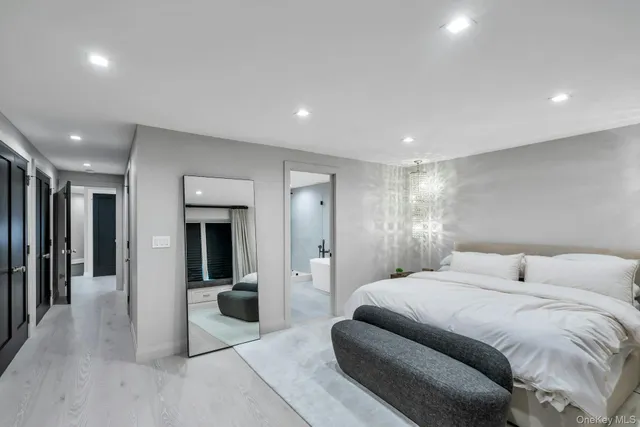 a spacious bedroom with a large bed and a chandelier