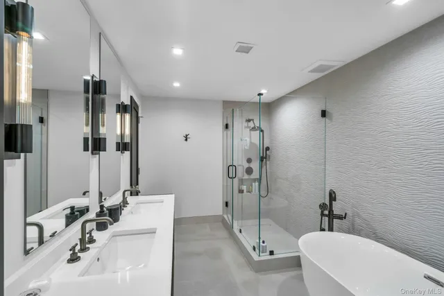 a bathroom with a tub sink and mirror