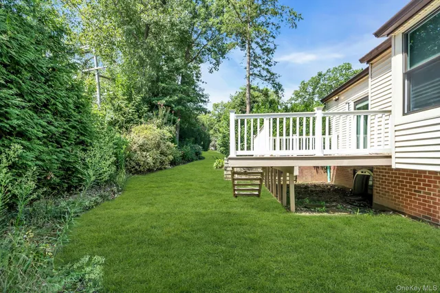 a view of a house with a backyard and a deck