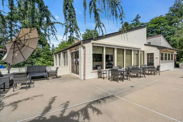 a view of a patio with table and chairs and a small yard