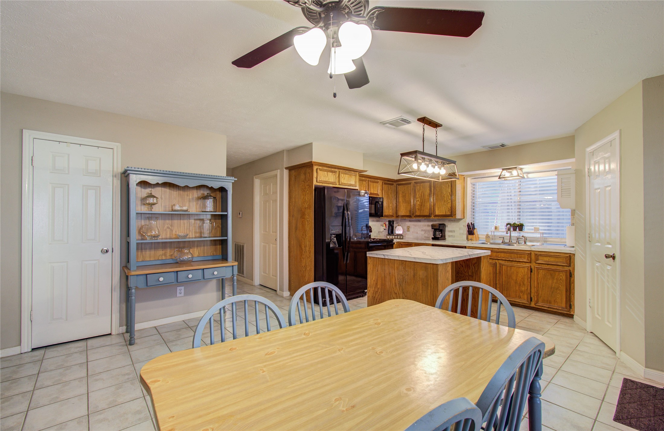 5927 Thom Road Humble, TX 77346 - Photo 12 of 50 The kitchen and breakfast area are filled with natural light and open seamlessly to the living room, offering lovely views of the back patio—perfect for gathering with family and friends.