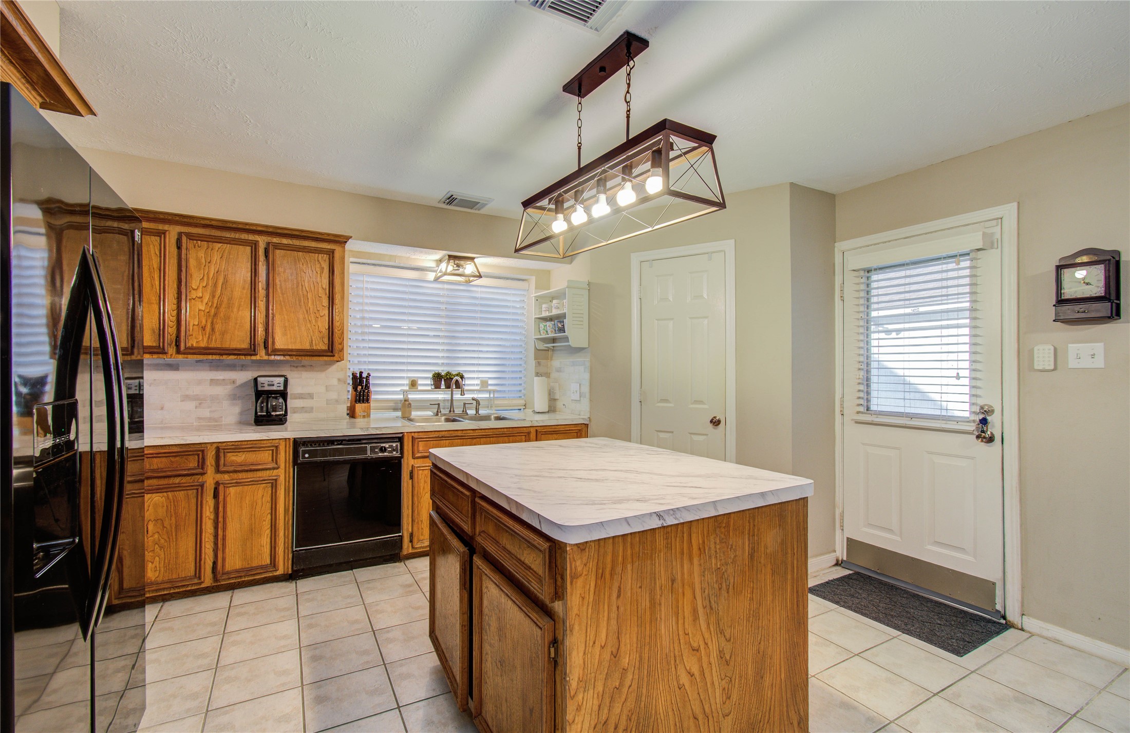 5927 Thom Road Humble, TX 77346 - Photo 14 of 50 The kitchen and breakfast area are filled with natural light and open seamlessly to the living room, offering lovely views of the back patio—perfect for gathering with family and friends.