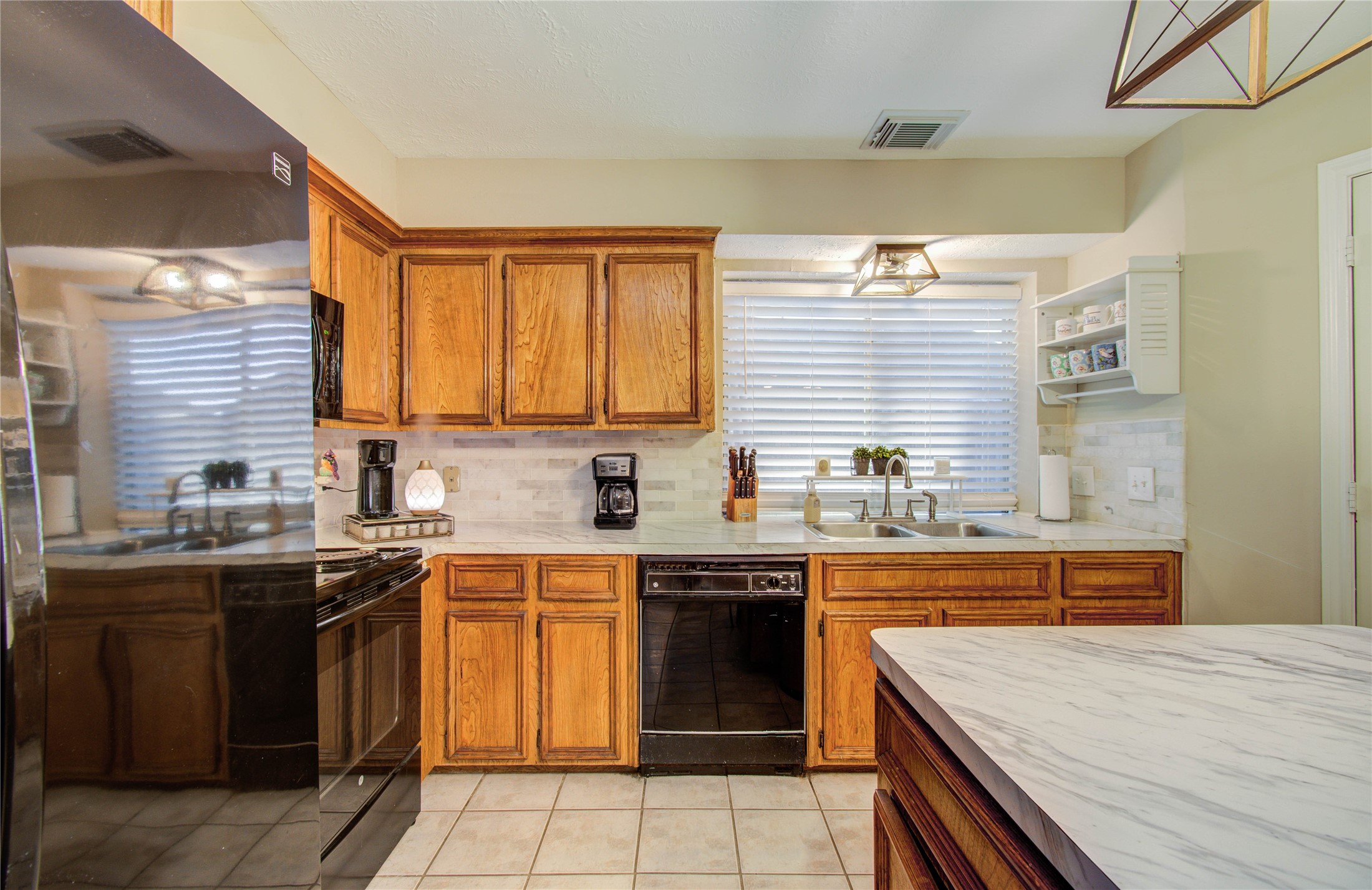 5927 Thom Road Humble, TX 77346 - Photo 15 of 50 The kitchen and breakfast area are filled with natural light and open seamlessly to the living room, offering lovely views of the back patio—perfect for gathering with family and friends.