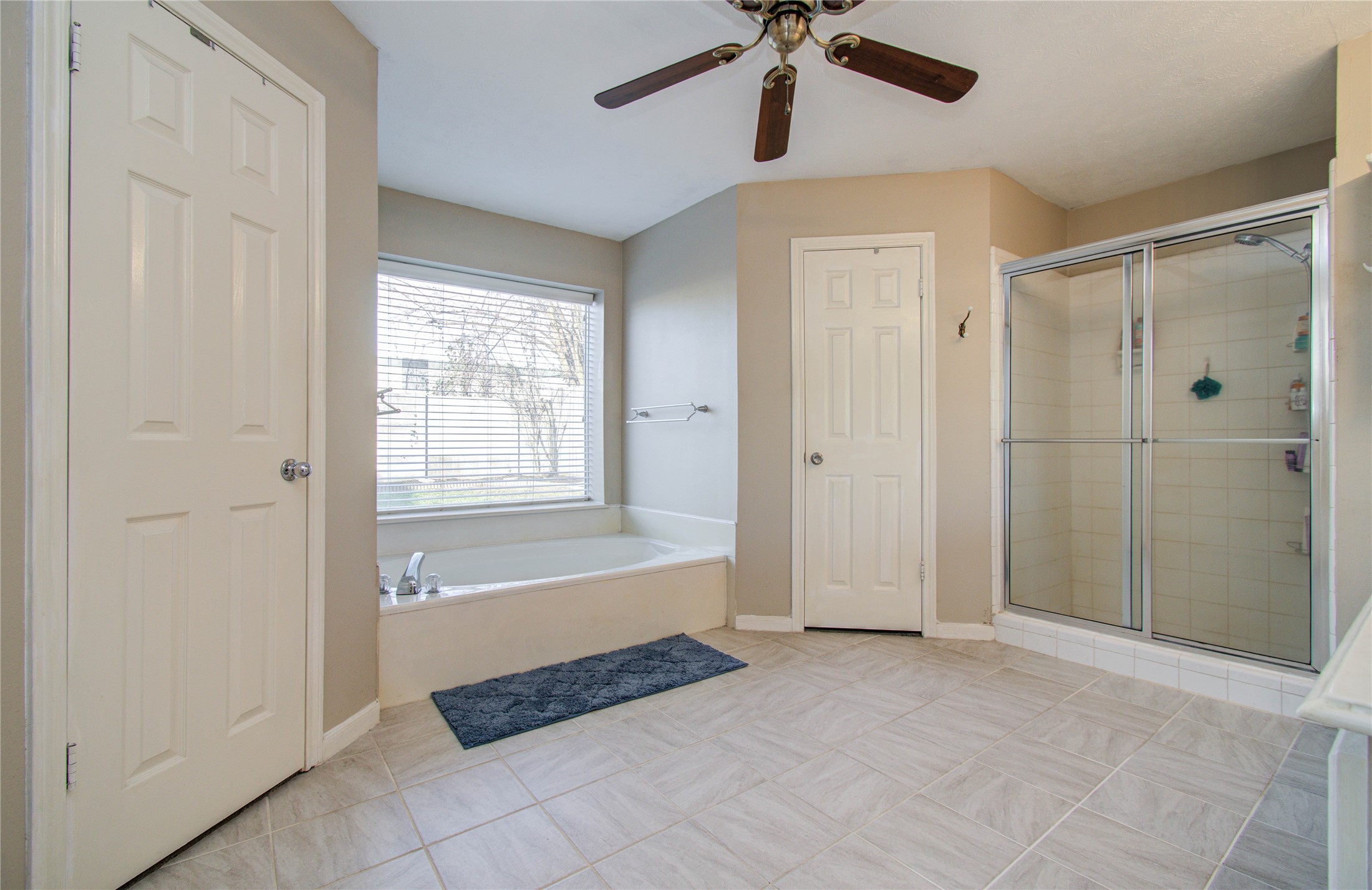 5927 Thom Road Humble, TX 77346 - Photo 21 of 50 The primary suite is generously sized and includes an oversized en-suite bath with his and her closets, double sinks, a vanity area, and a separate tub and shower.