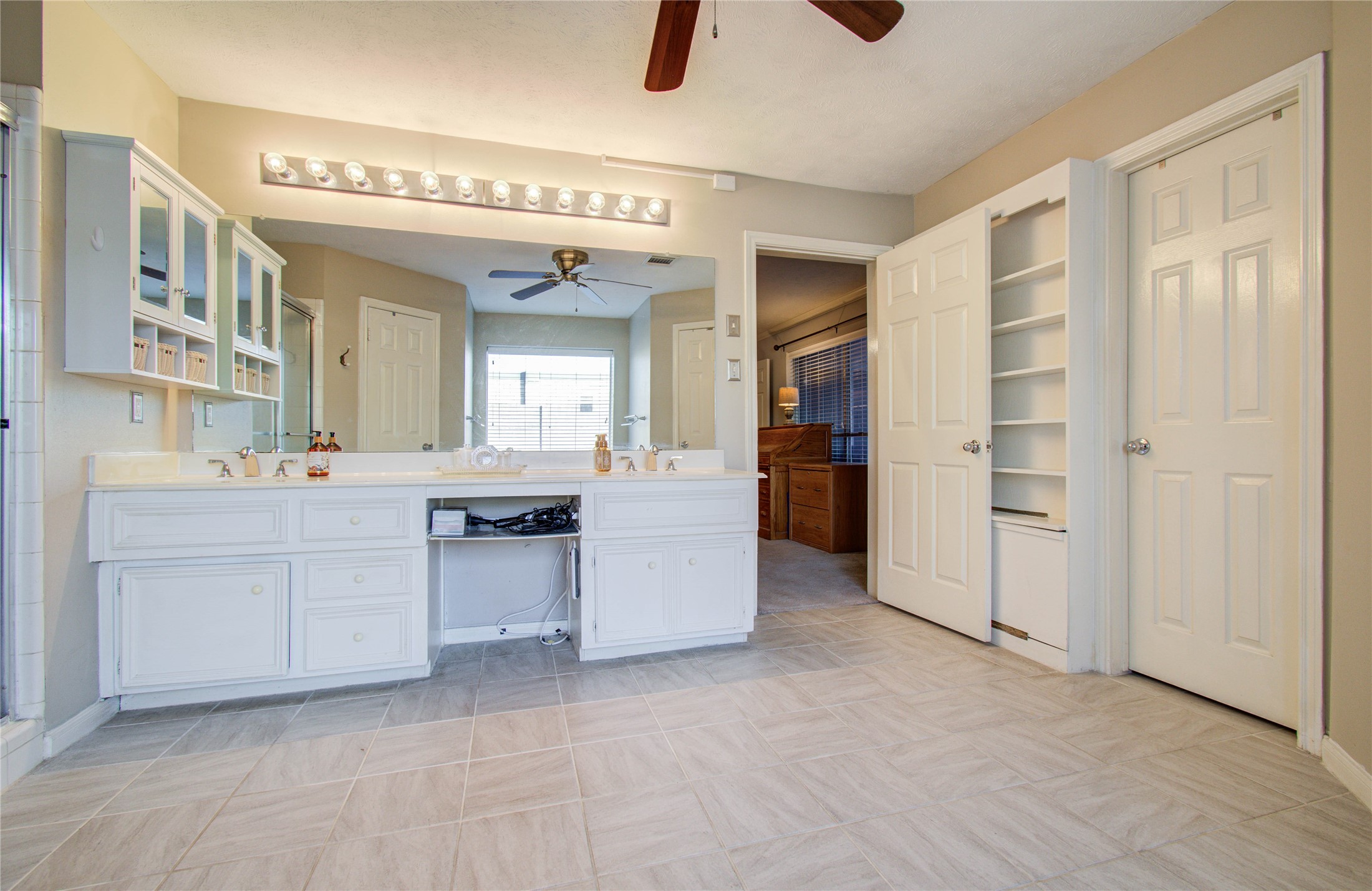 5927 Thom Road Humble, TX 77346 - Photo 22 of 50 The primary suite is generously sized and includes an oversized en-suite bath with his and her closets, double sinks, a vanity area, and a separate tub and shower.