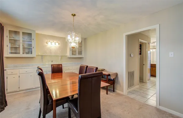 a view of a dining room with furniture and chandelier
