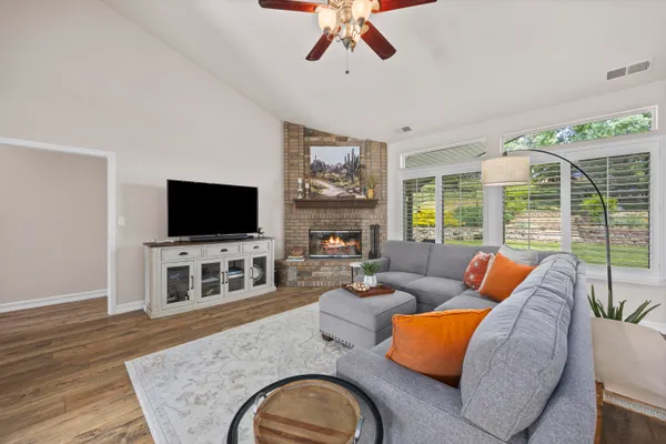 a living room with furniture a flat screen tv and a fireplace