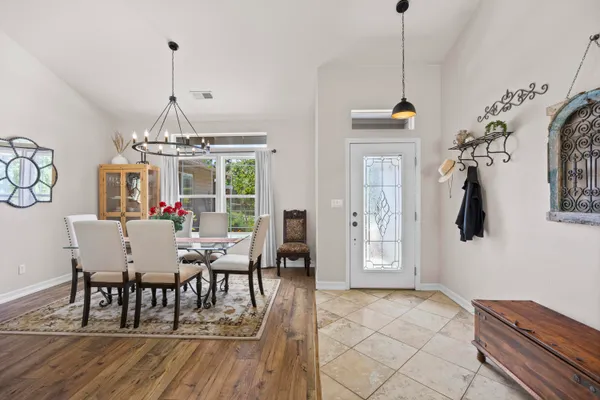 a dining room with furniture a chandelier and wooden floor