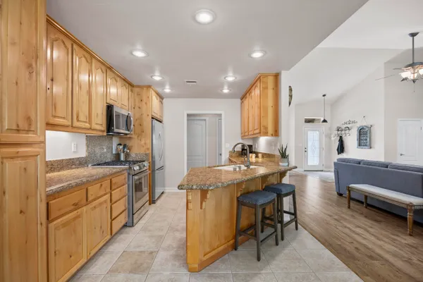 a kitchen with stainless steel appliances granite countertop a stove a sink and a microwave