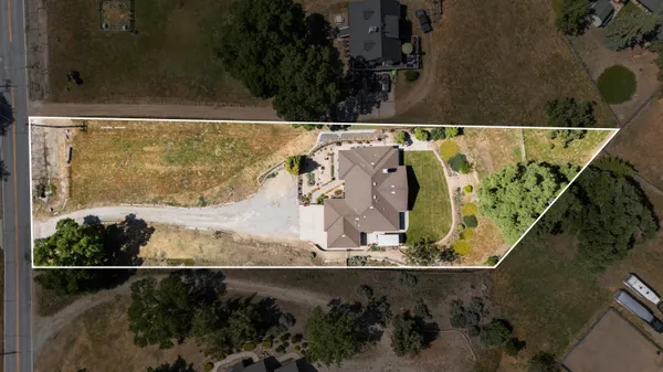 an aerial view of a house with a yard and a lake view