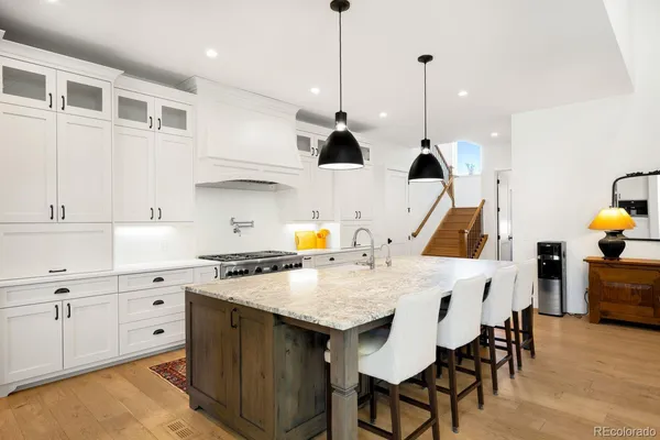 a kitchen with a sink a stove a dining table and chairs