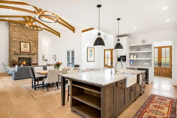 a kitchen with a table chairs stove and wooden floor