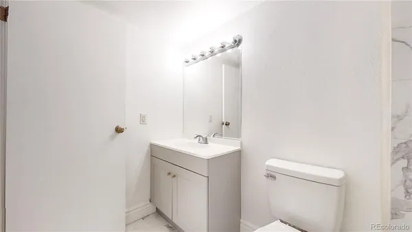a bathroom with a sink a toilet and a mirror