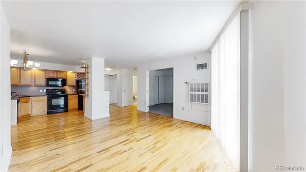 a view of a kitchen with kitchen island wooden floor center island and appliances