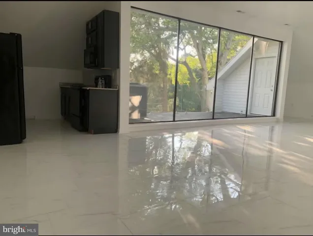 a view of a hallway with wooden floor and a living room