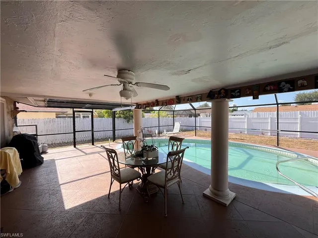 a view of a patio with a table chairs and a floor to ceiling window