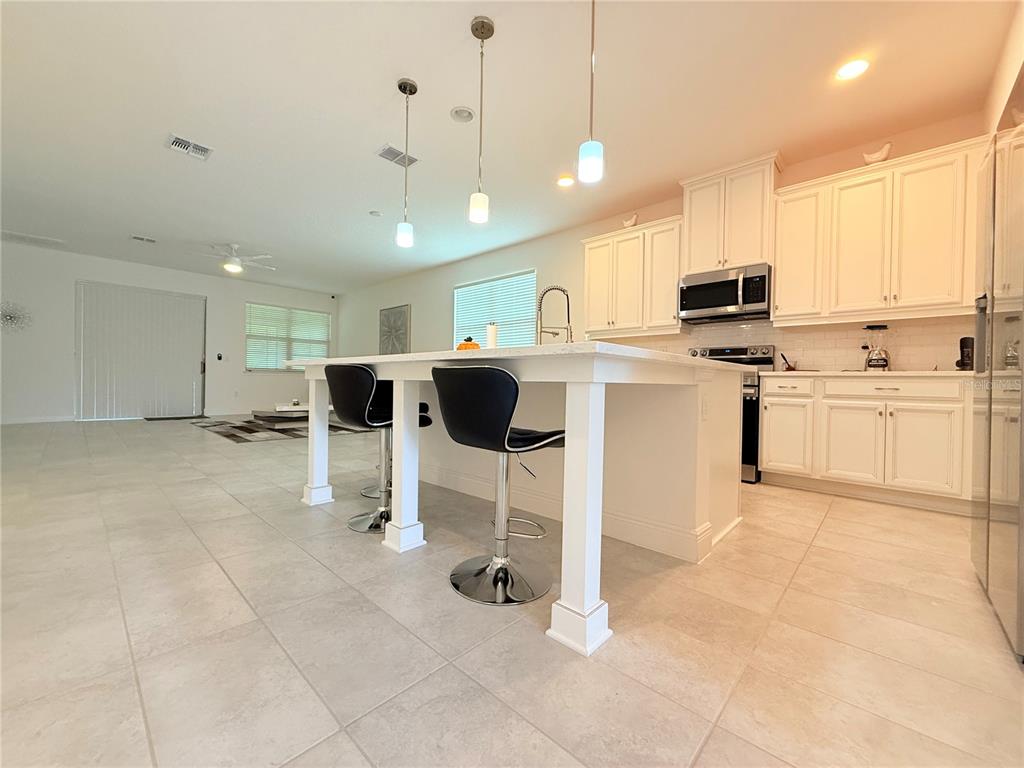 3112 Oxbow Court Harmony, FL 34773 - Photo 4 of 22 a kitchen with stainless steel appliances kitchen island granite countertop a sink and cabinets