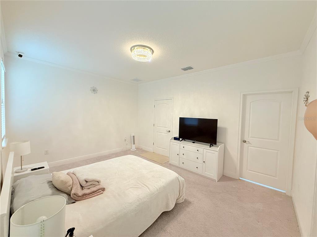 3112 Oxbow Court Harmony, FL 34773 - Photo 8 of 22 a bedroom with a bed and a flat screen tv
