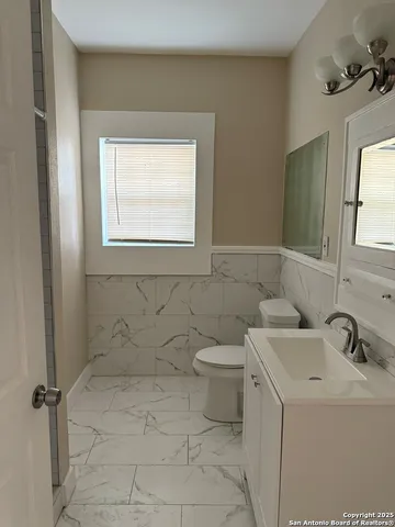 a bathroom with a sink a toilet and a mirror