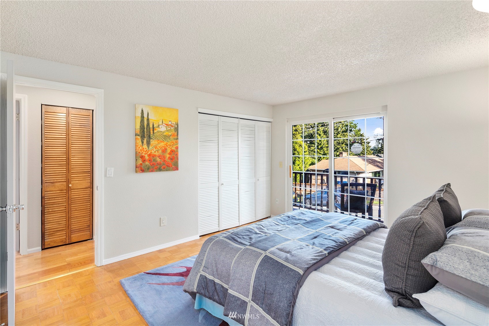 4800 South Frontenac Street Seattle, WA 98118 - Photo 18 of 40 a bedroom with a bed and wooden floor
