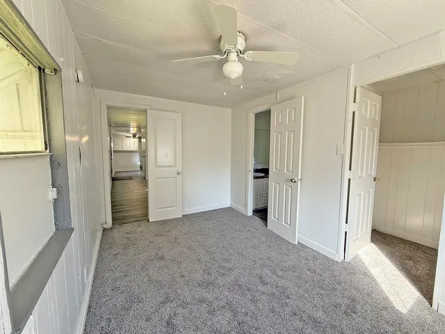an empty room with fan and entrance