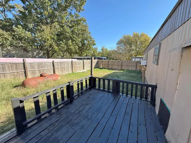 a view of balcony with wooden floor and fence