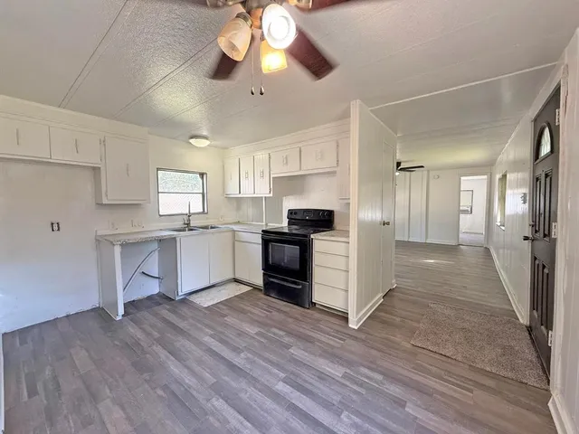 a kitchen with a refrigerator and white cabinets