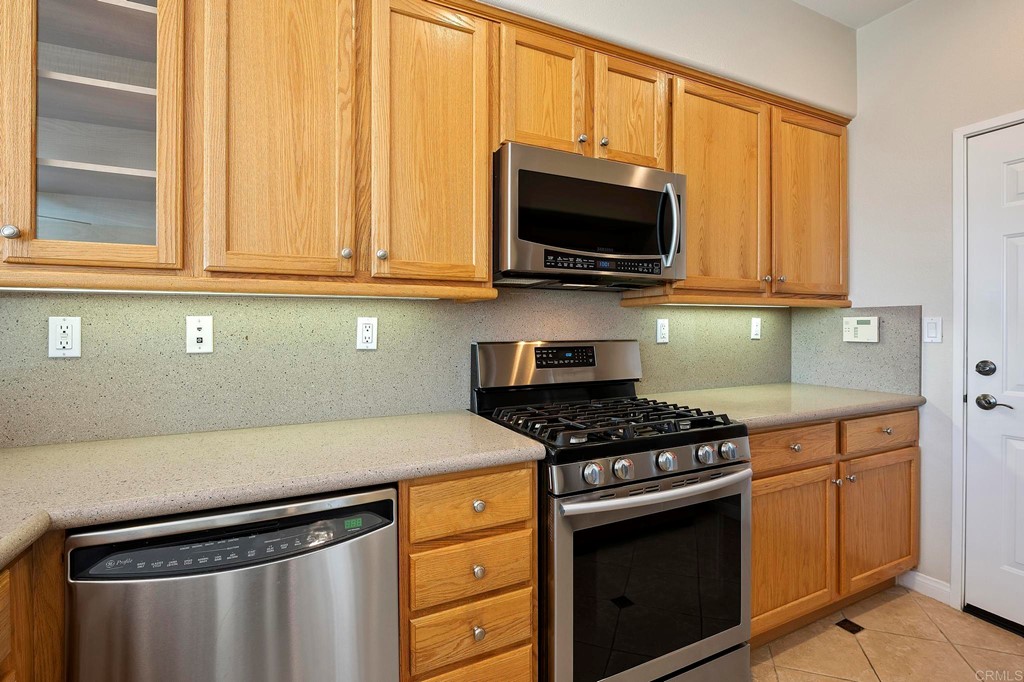 1295 Highbluff Avenue San Marcos, CA 92078 - Photo 16 of 38 a kitchen with stainless steel appliances granite countertop a stove and a microwave