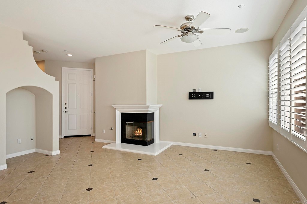 1295 Highbluff Avenue San Marcos, CA 92078 - Photo 8 of 38 a view of a livingroom with a fireplace a ceiling fan and windows