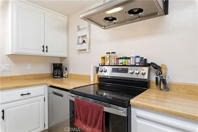 a kitchen with a stove and a white cabinets