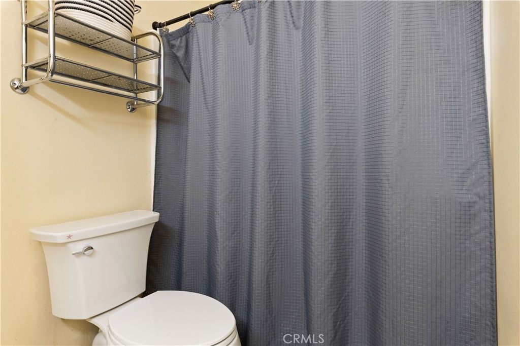 2225 Ladder Ridge Road Upper Lake, CA 95485 - Photo 27 of 58 a white toilet sitting next to a shower curtain