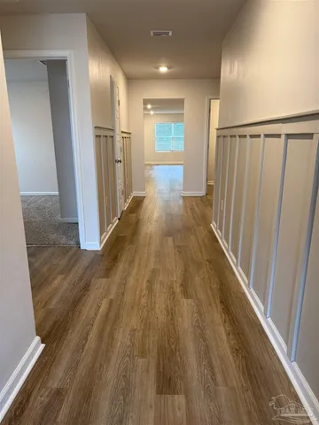 a view of a hallway with wooden floor