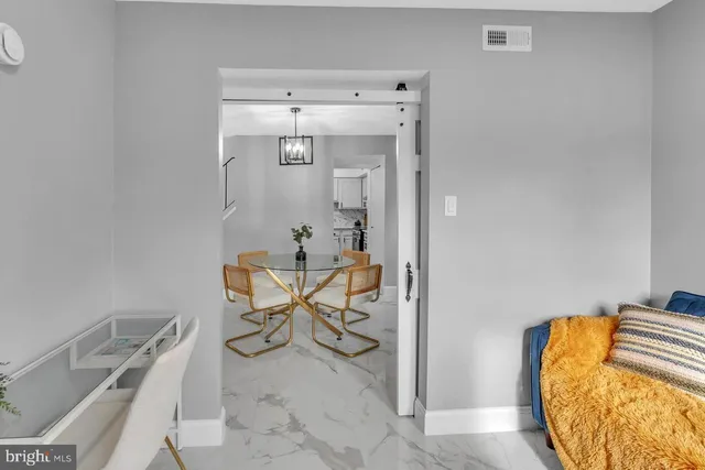 a view of a kitchen with white cabinets and wooden floor