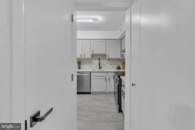 a view of a kitchen with a sink a stove top oven