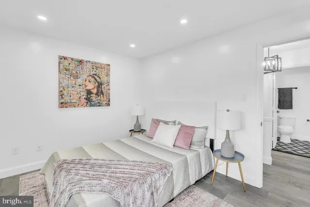 a spacious bedroom with a bed a couch and a lamp on table